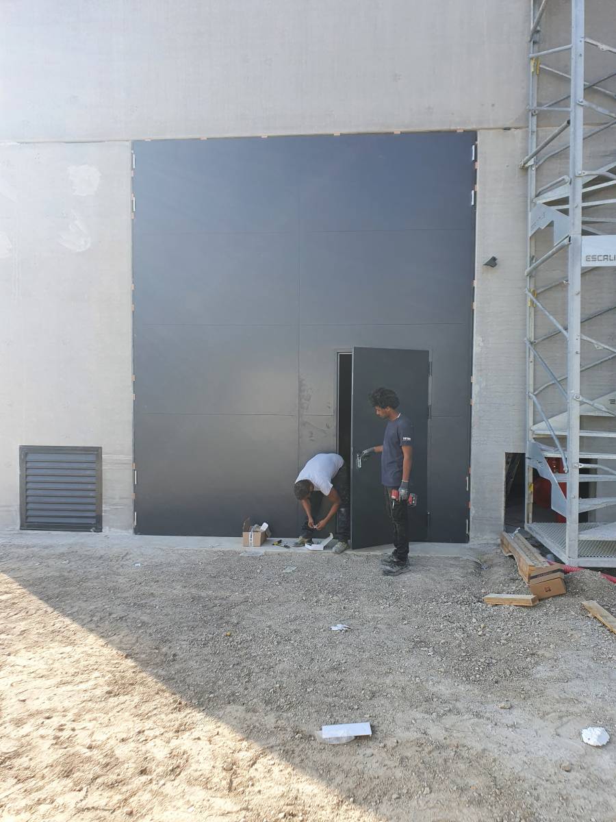 Installation d'une porte de grande dimension en acier sur Marseille.